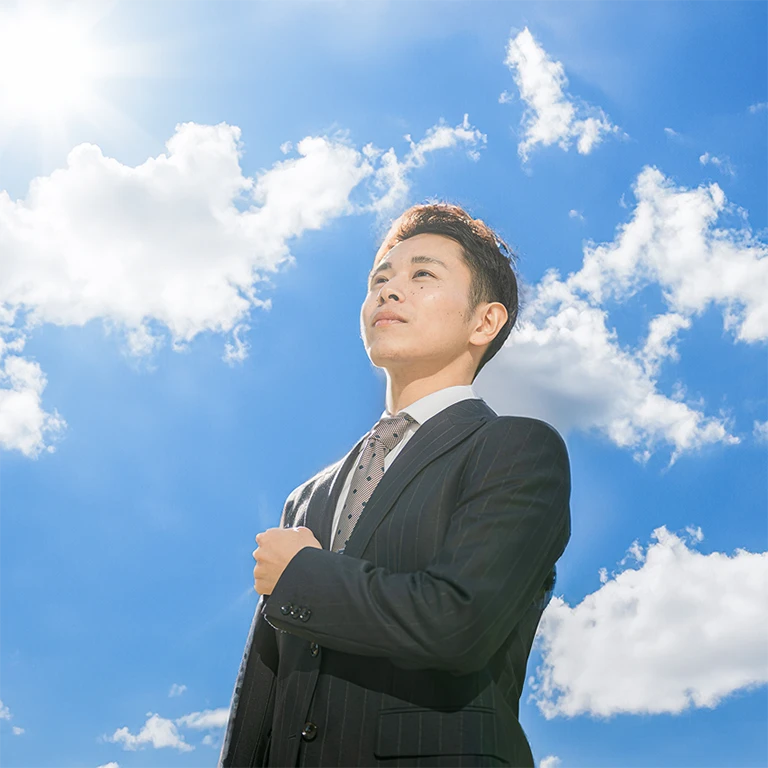 Young man in suit with bright sky in background