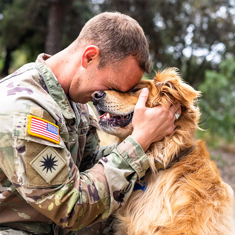 Veteran man hugging his dog close