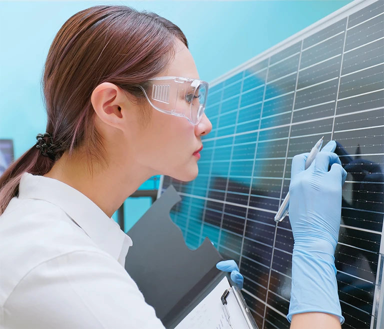 Woman carefully inspecting solar cells