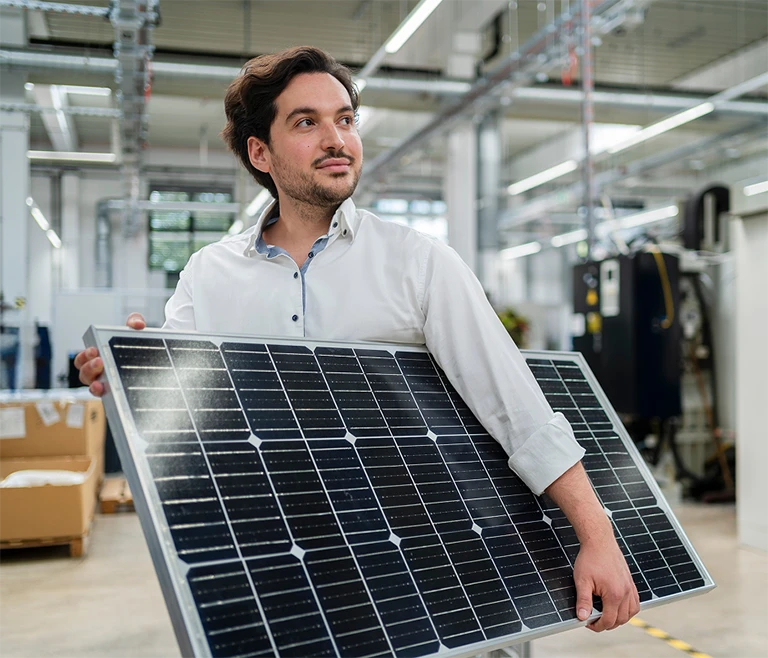 Employee in warehouse holding a solar panel